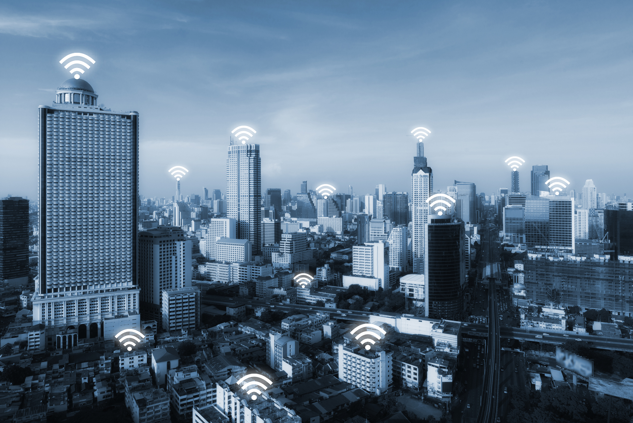 Small cell and DAS symbolized on city skyline with cell signal icons.
